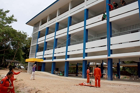 Firefighters give the students a demonstration of how they might evacuate an injured person from the 3rd floor of a burning building.